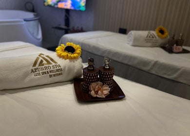Relaxing spa setup with branded towel and flowers at Azurro Spa by Niyama - Avani IBN Batuta, دبي, AE.