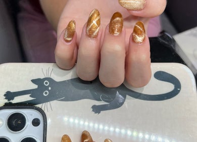 Golden glitter nails at Helen's Nails & Spa in Wildwood, Florida, US, showcasing intricate nail art design.