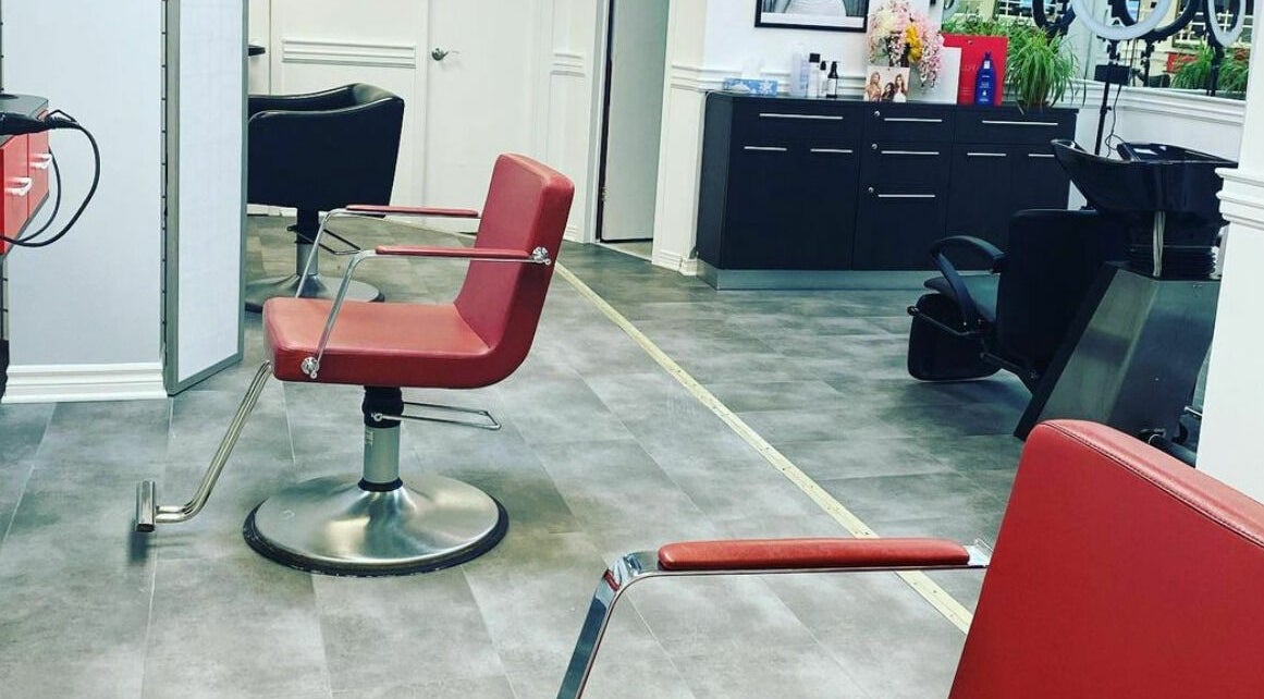 Modern salon interior at Hair Heaven, Ottawa, Ontario, CA. Features red chairs and stylish decor.