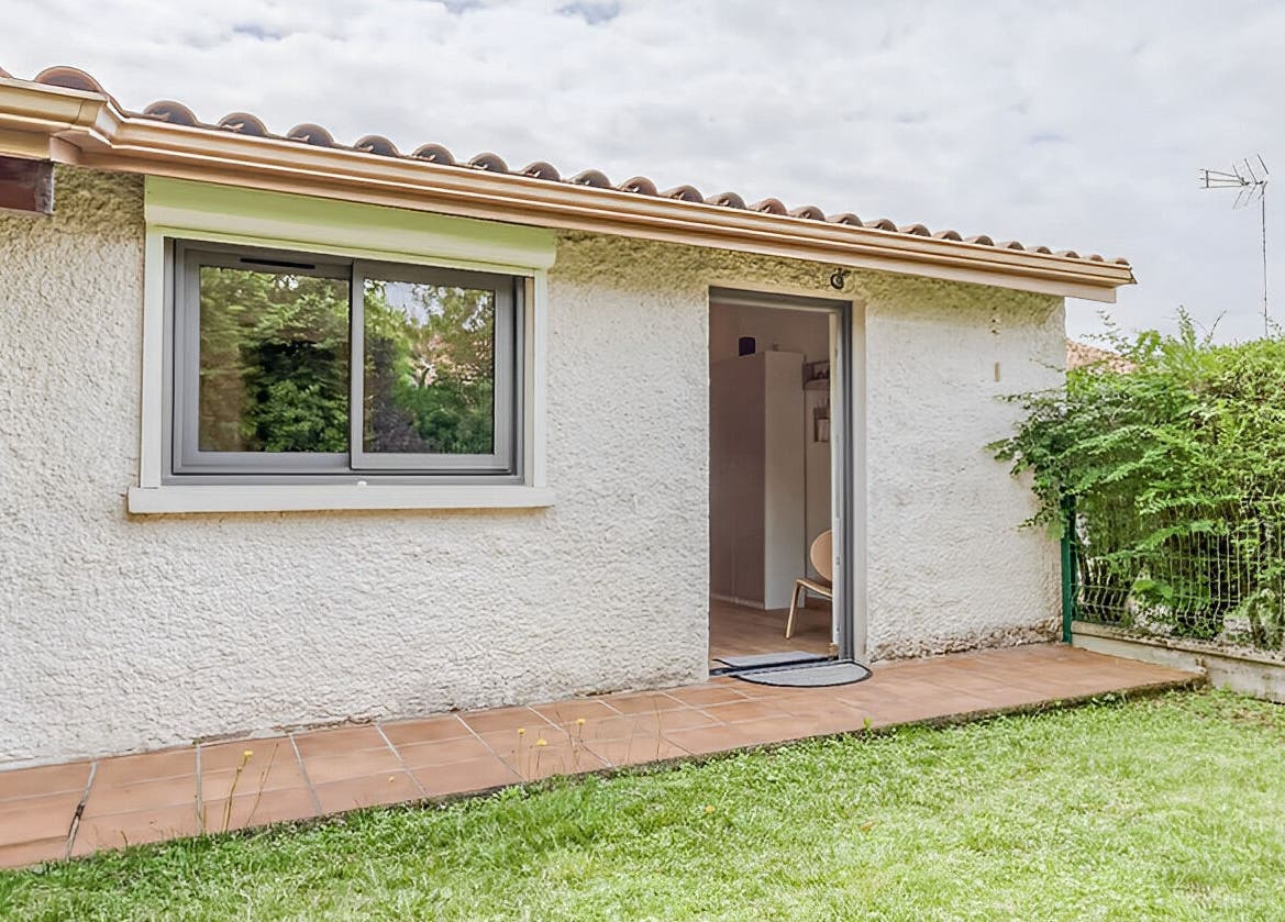 Entrée accueillante d'Eric BienEtre à Pessac, FR, avec terrasse ensoleillée et verdure luxuriante.