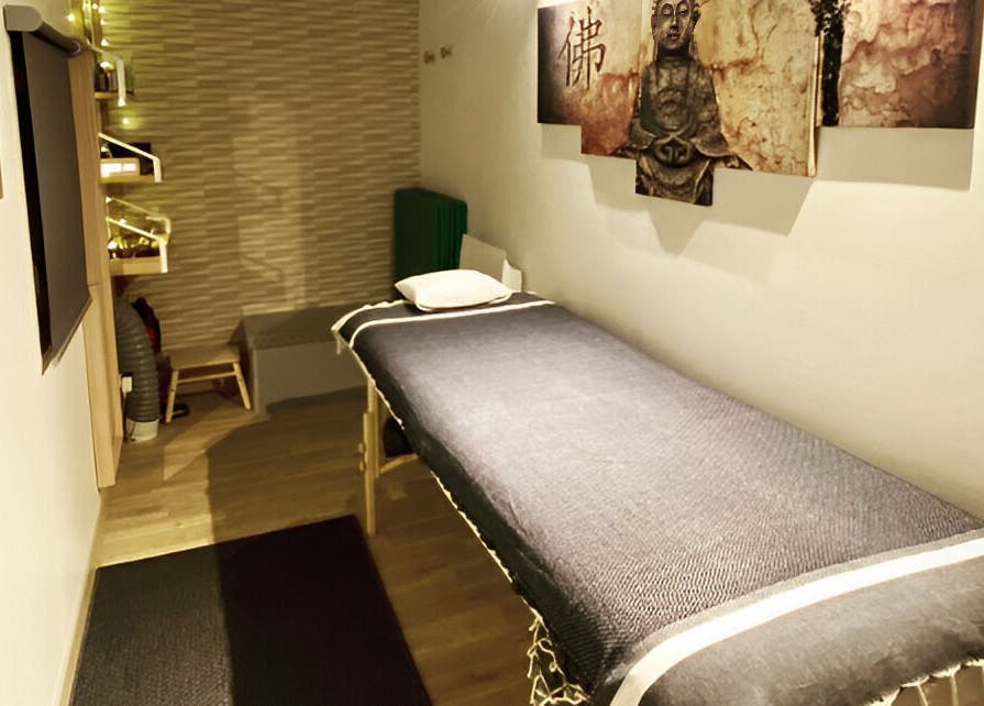 Salle de soin apaisante chez Eric BienEtre à Pessac, FR avec une table de massage et décor zen.