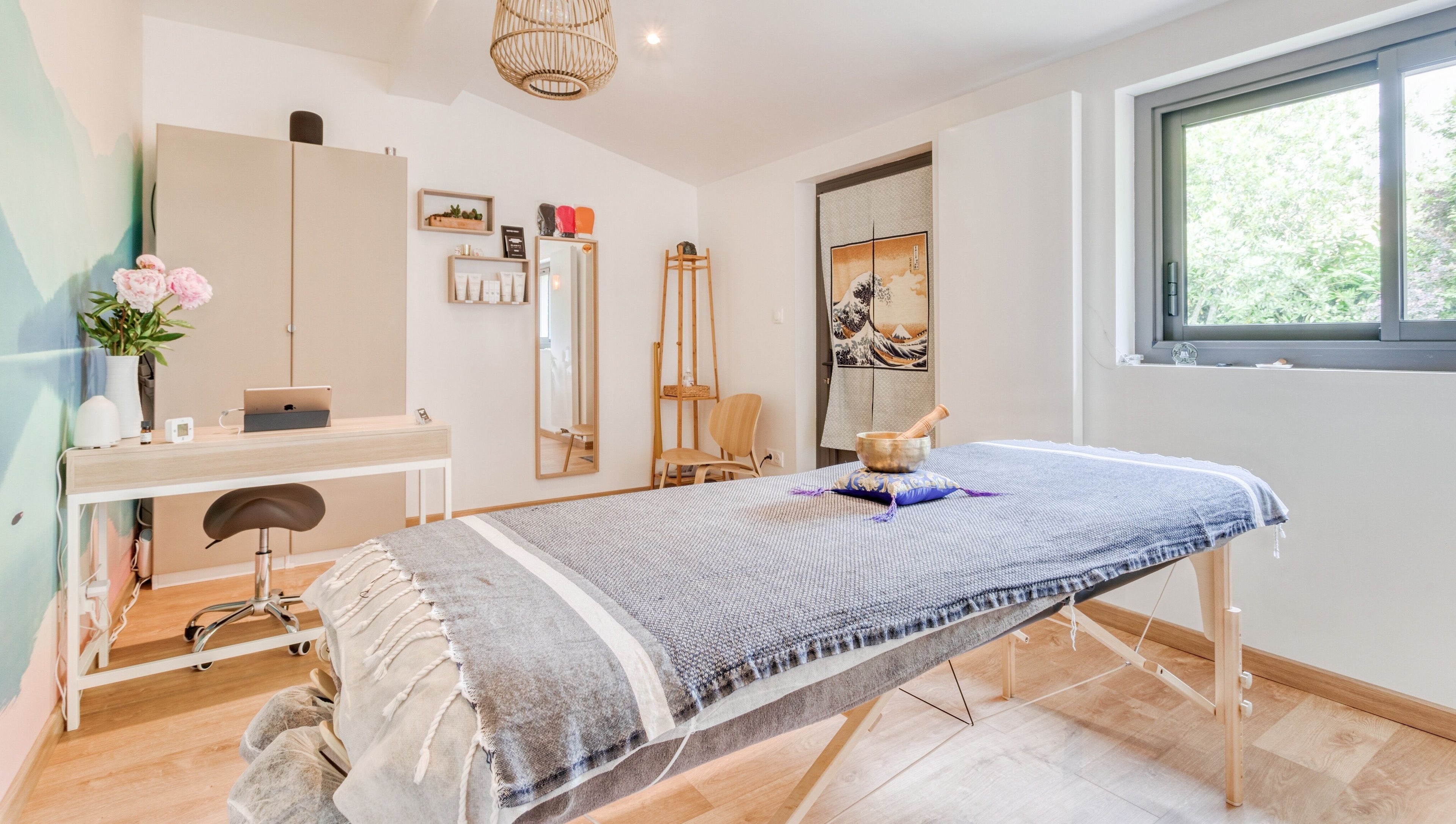 Salle de soin relaxante chez Eric BienEtre à Pessac, FR, avec table de massage et lumière naturelle.