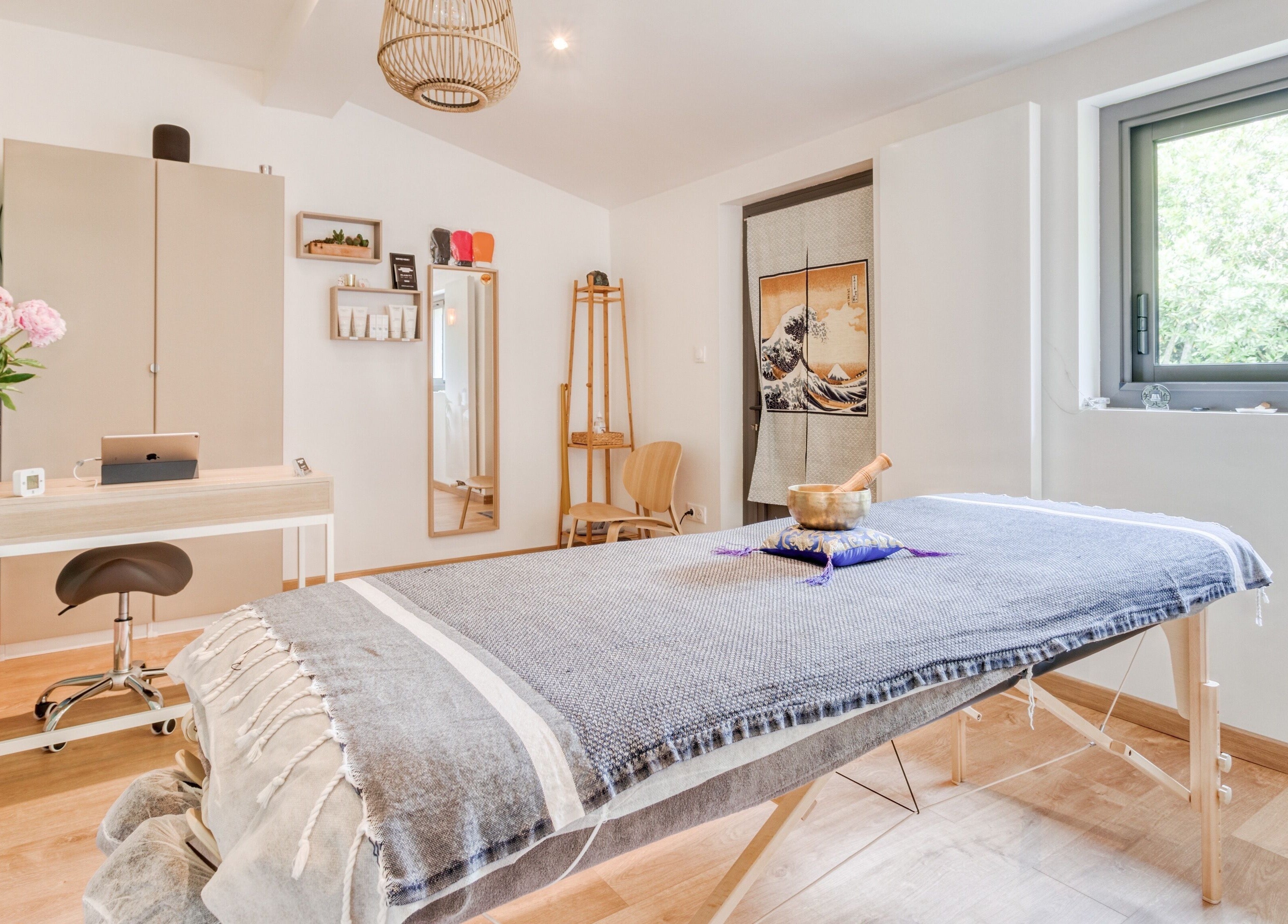 Salle de soin relaxante chez Eric BienEtre à Pessac, FR, avec table de massage et lumière naturelle.