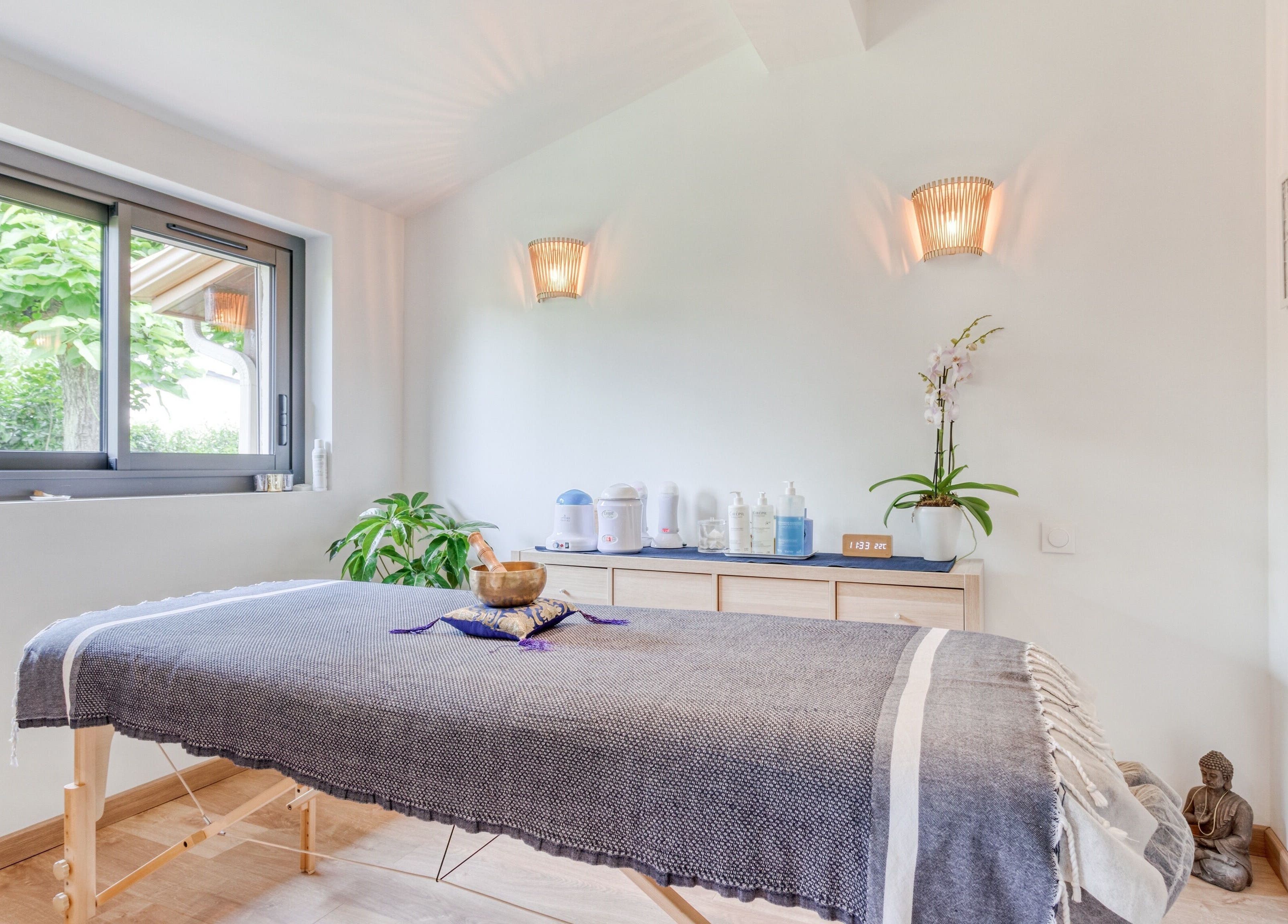 Salle de soin lumineuse chez Eric BienEtre à Pessac, FR, avec table de massage et décor apaisant.