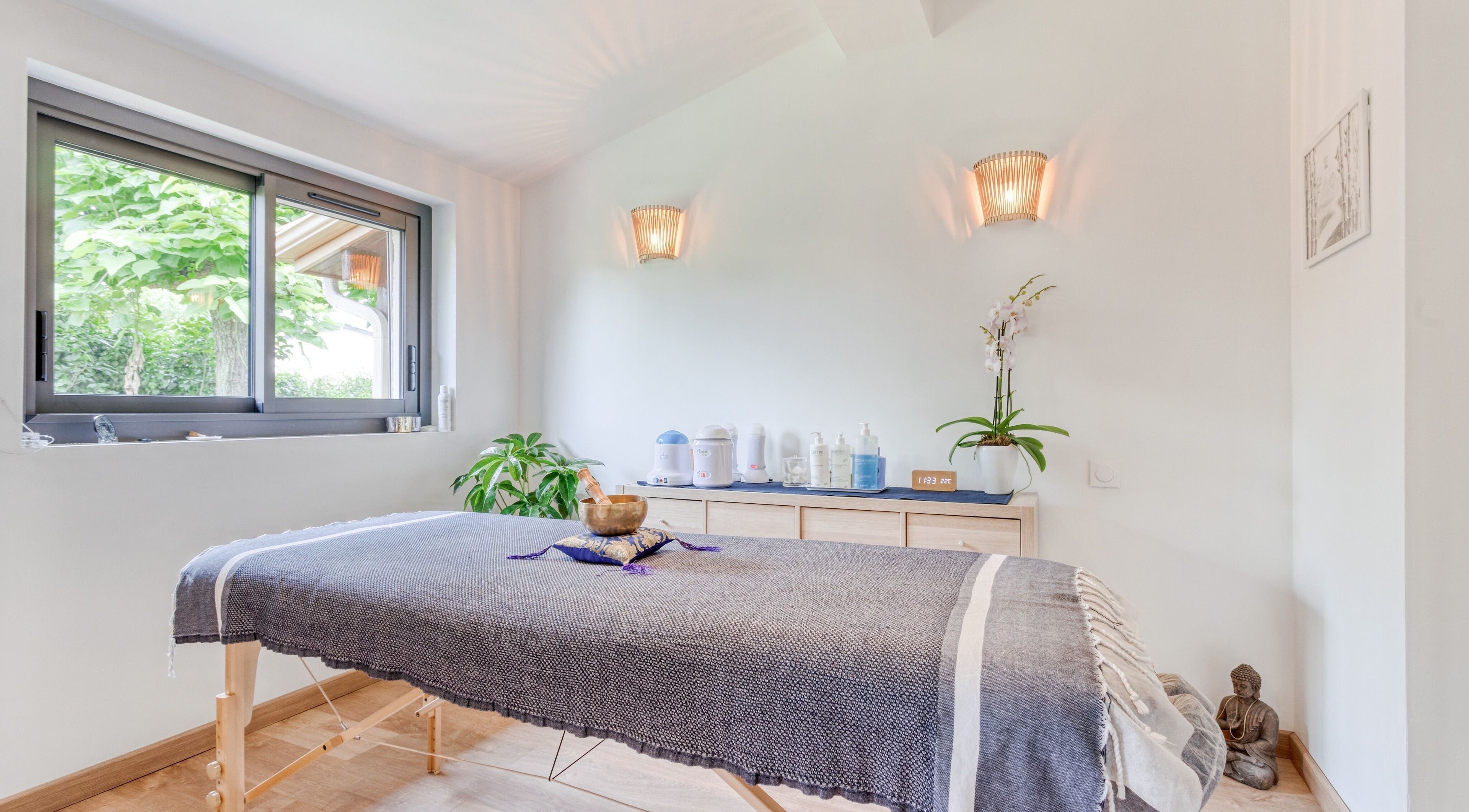Salle de soin lumineuse chez Eric BienEtre à Pessac, FR, avec table de massage et décor apaisant.