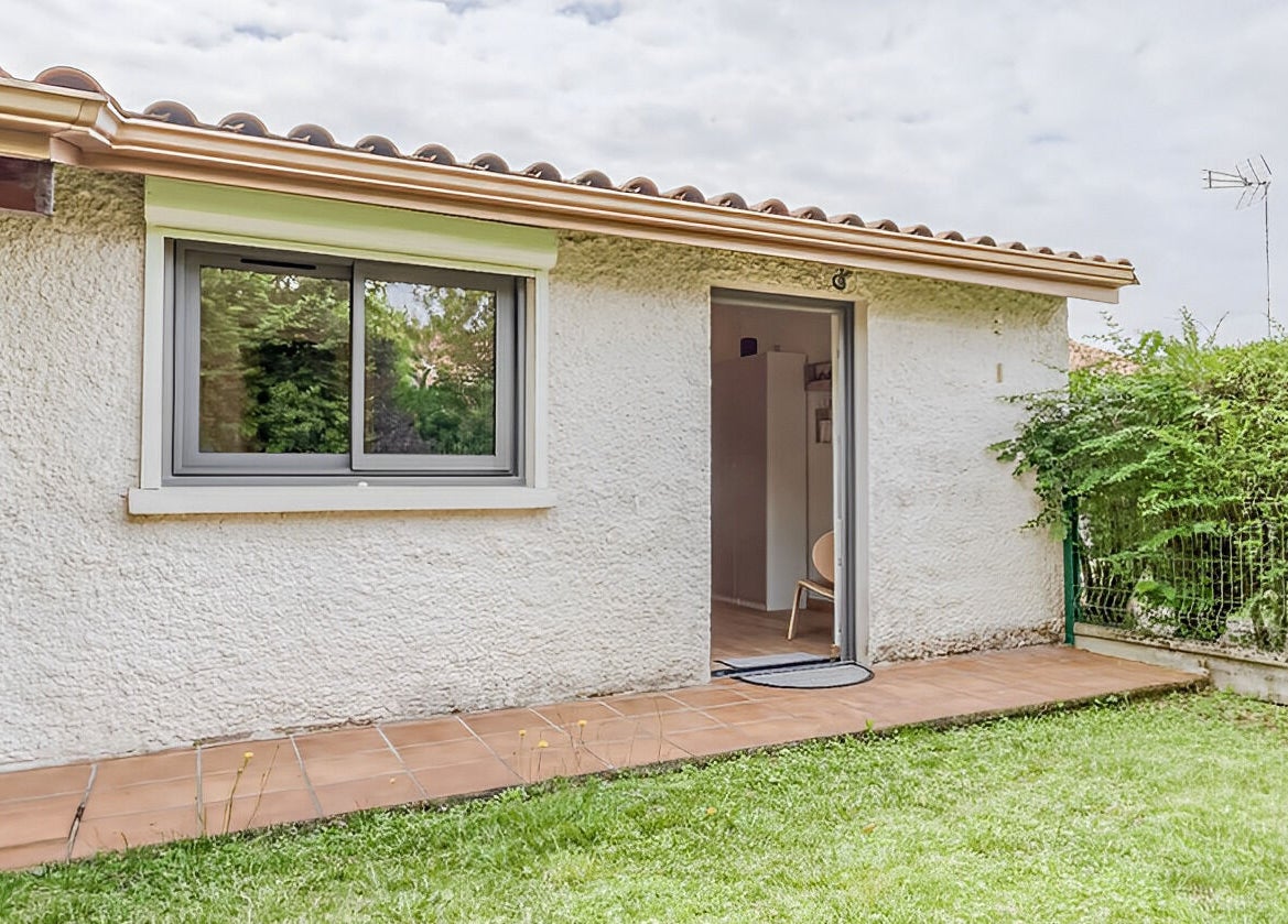 Entrée lumineuse de Eric BienEtre à Pessac, FR avec terrasse dallée et verdure environnante.
