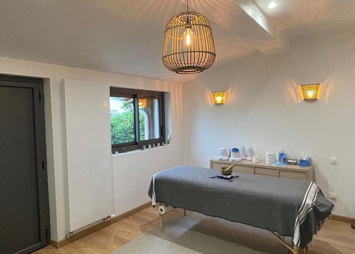 Salle de massage apaisante à Eric BienEtre, Pessac, FR, avec lit de massage et éclairage chaleureux.