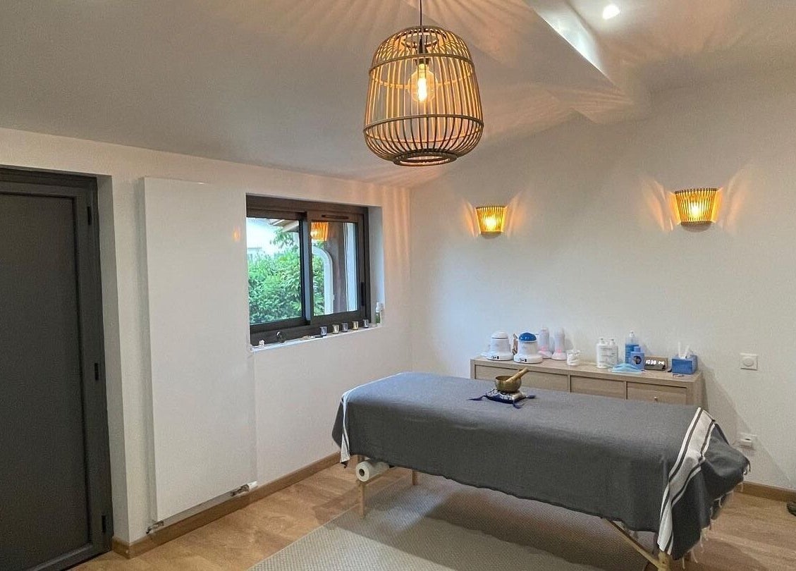 Salle de massage apaisante à Eric BienEtre, Pessac, FR, avec lit de massage et éclairage chaleureux.