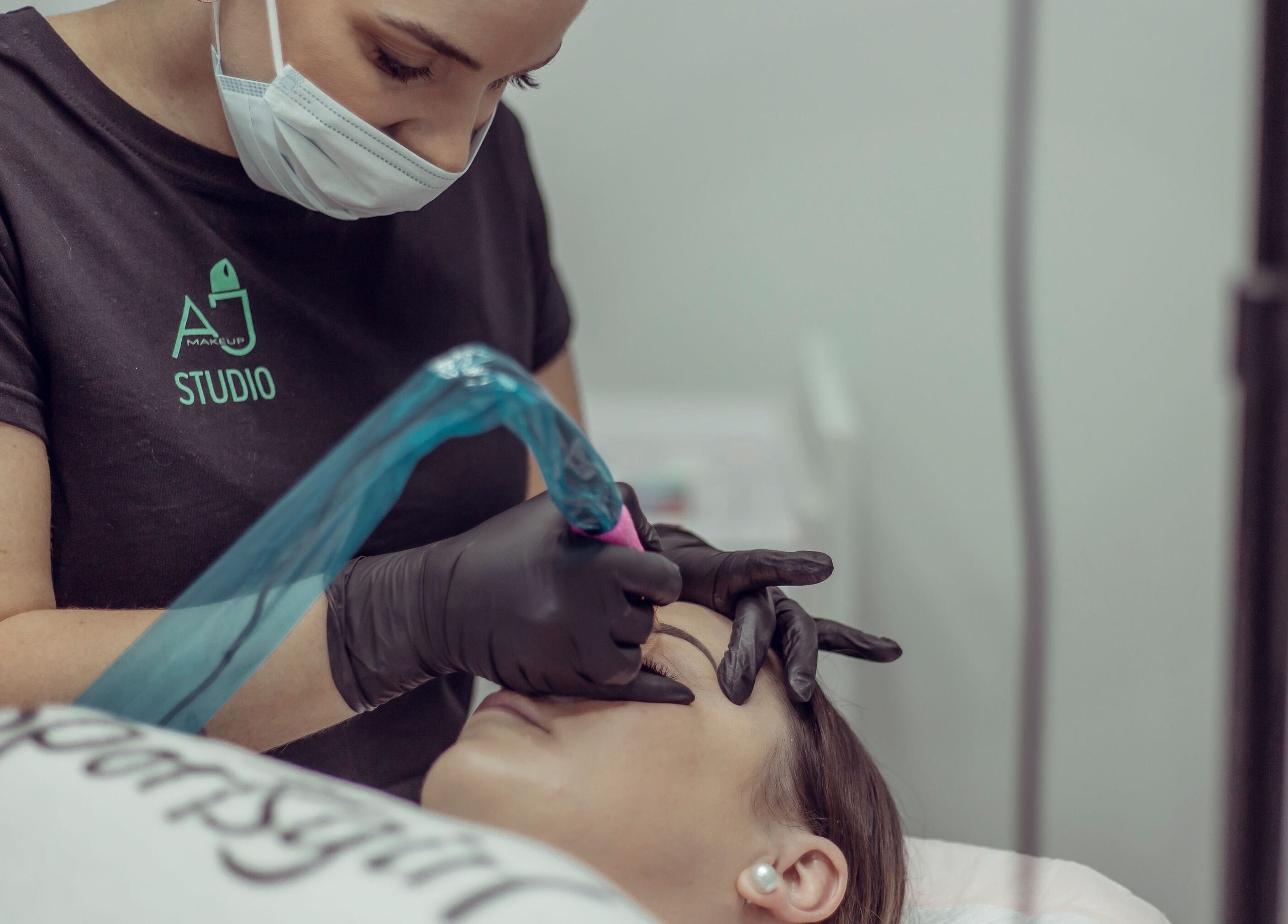 Artist at AJ Makeup Studio, Launceston, Tasmania, AU, applies precise makeup with focus on detail.