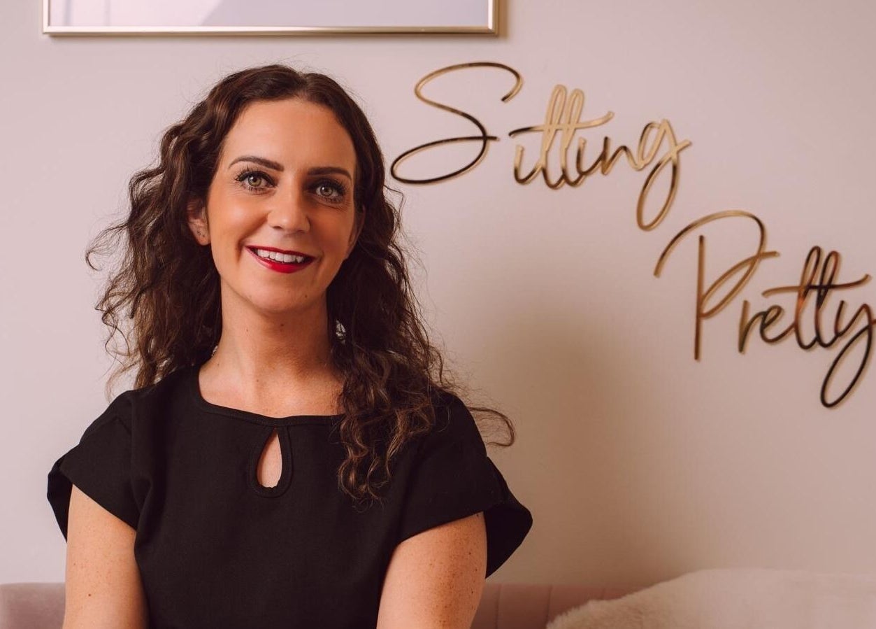 A warm welcome at RJ Beauty, Halifax, England, GB, featuring chic decor and a smiling staff member.