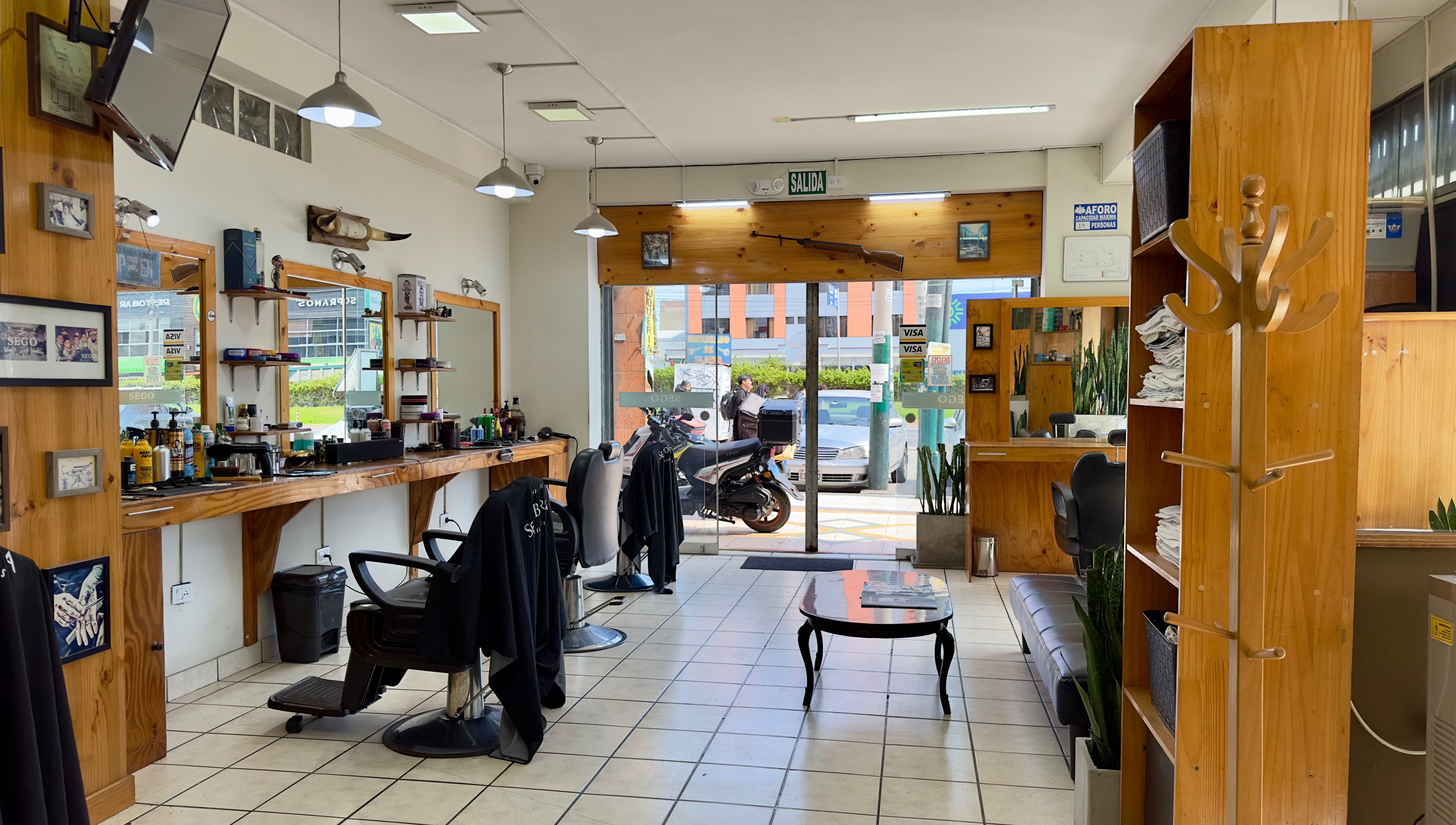 Interior de Sego Barberia en Pueblo Libre, Municipalidad Metropolitana de Lima, PE, mostrando sillas y espejos elegantes.