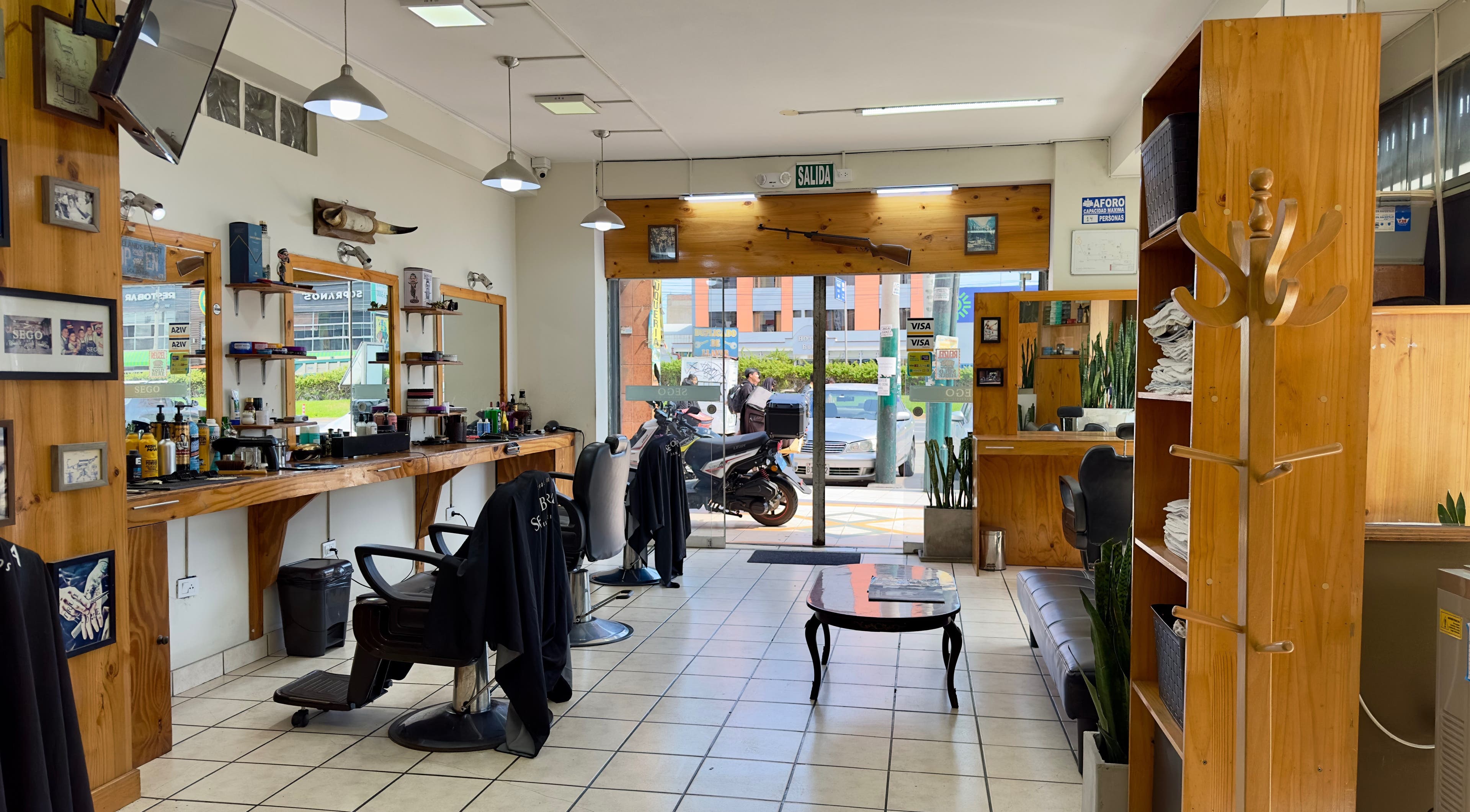 Interior de Sego Barberia en Pueblo Libre, Municipalidad Metropolitana de Lima, PE, mostrando sillas y espejos elegantes.