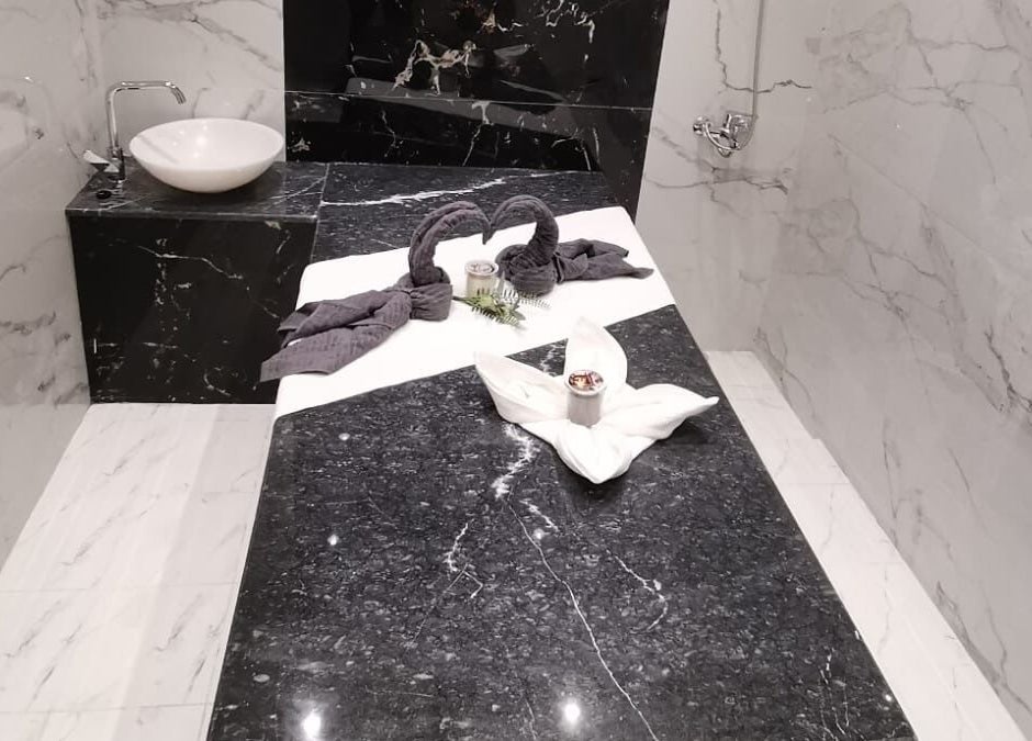 Luxurious spa table at Energy Spa Riffa, Riffa, Al-Muḥāfaẓat al-Janūbīyah, BH with folded towels and marble decor.