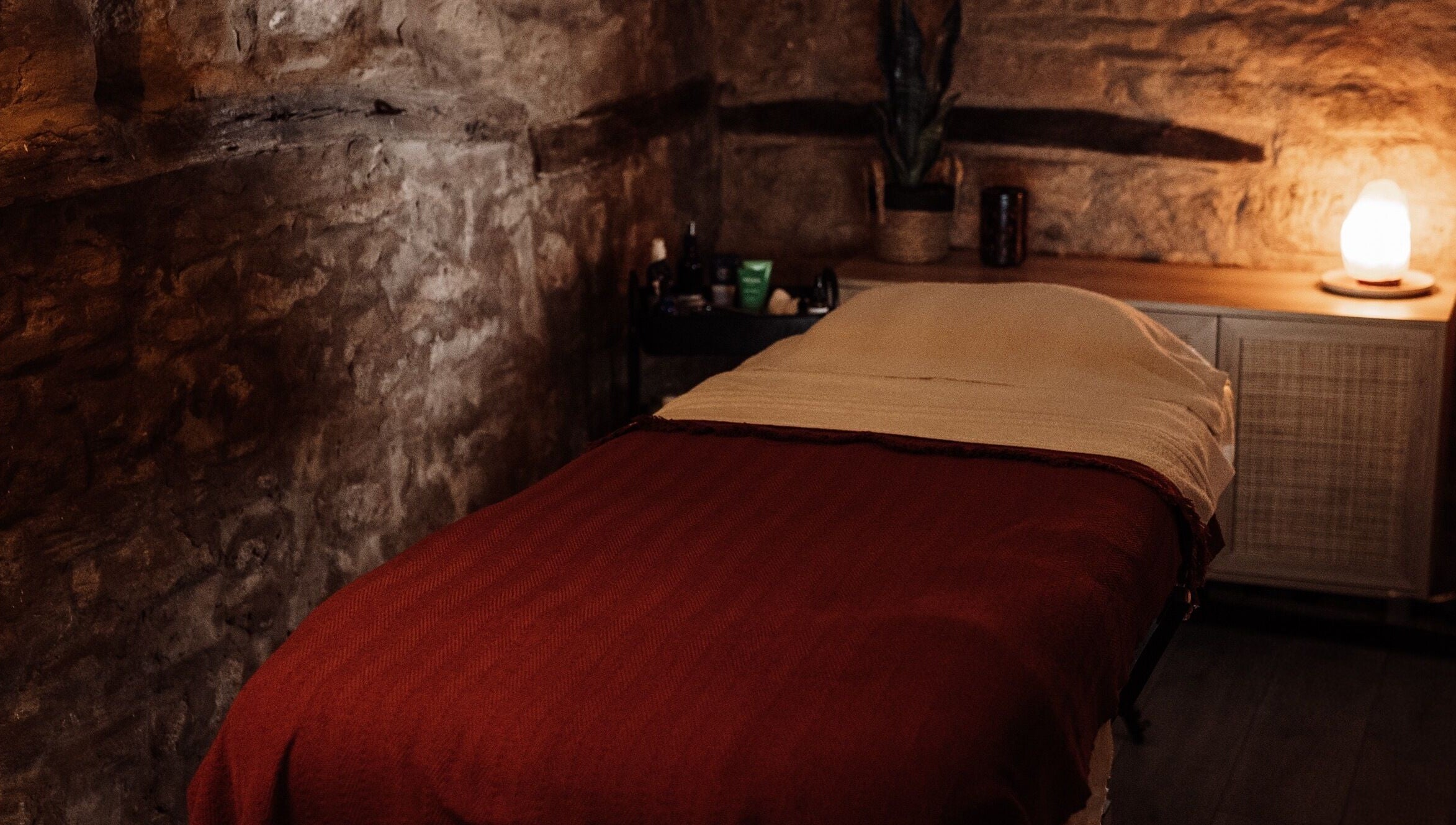 Relaxing massage room at House of Soul Feniscowles, Feniscowles, England, GB with warm lighting and stone walls.