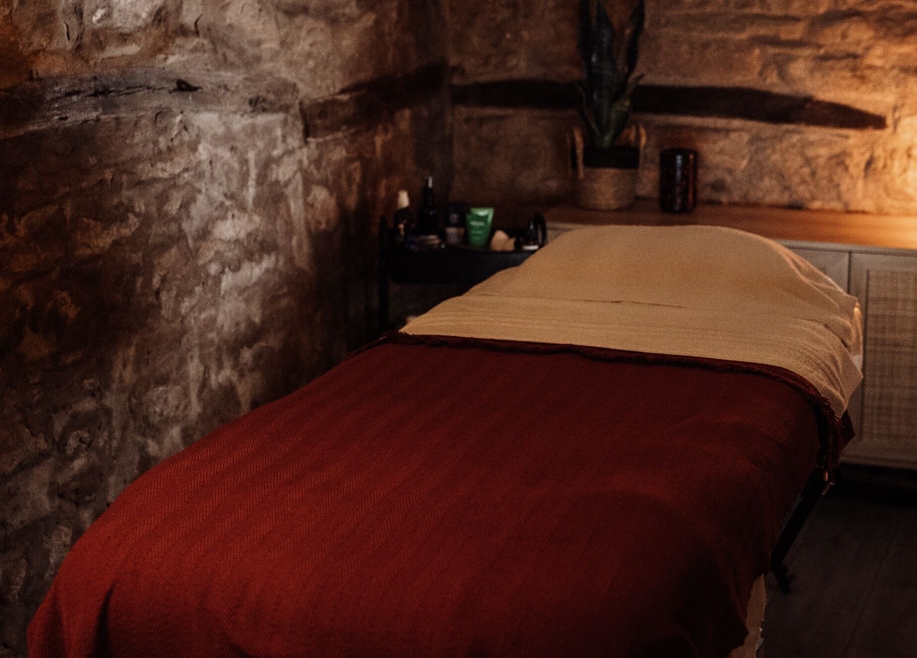 Relaxing massage room at House of Soul Feniscowles, Feniscowles, England, GB with warm lighting and stone walls.