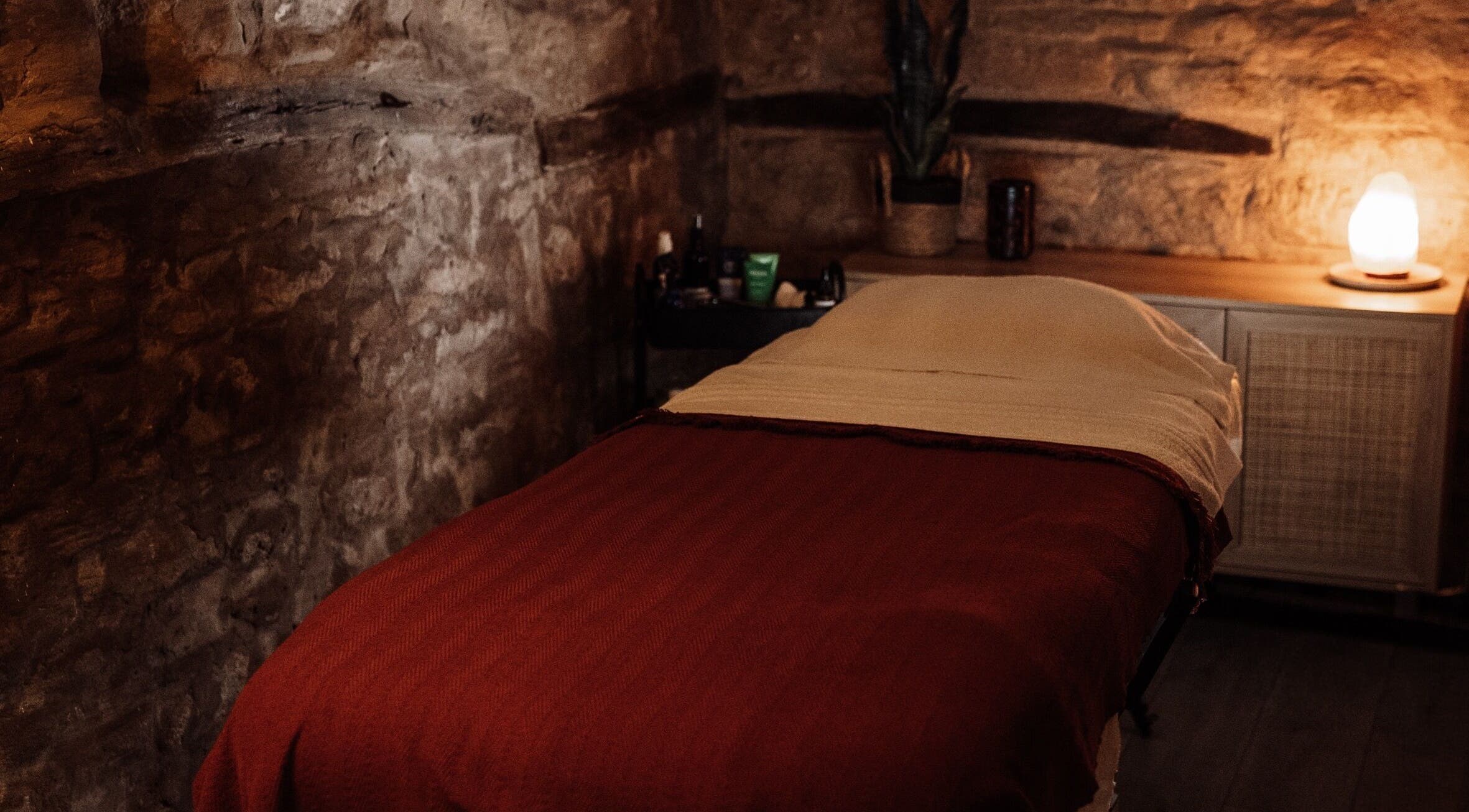 Relaxing massage room at House of Soul Feniscowles, Feniscowles, England, GB with warm lighting and stone walls.