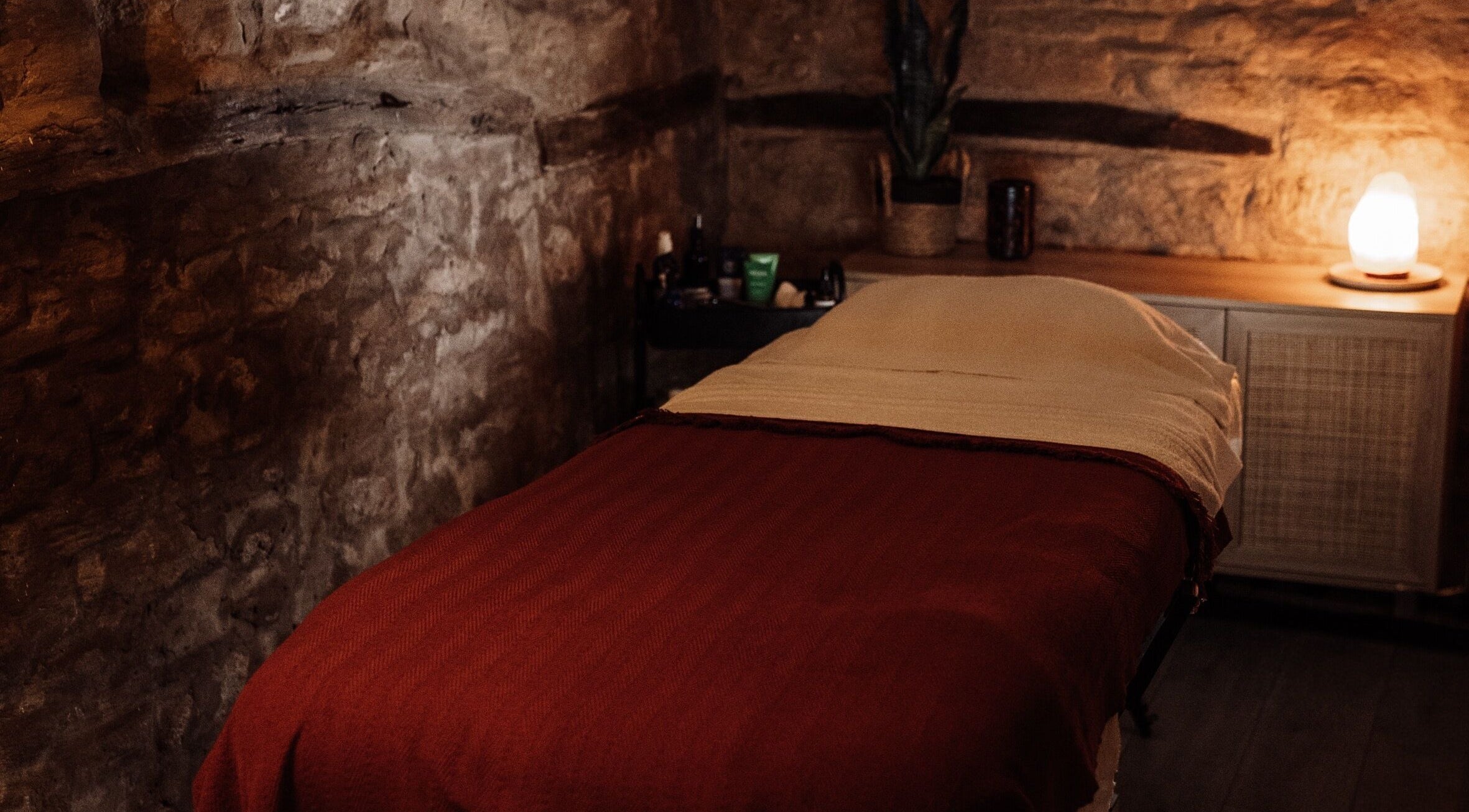 Relaxing massage room at House of Soul Feniscowles, Feniscowles, England, GB with warm lighting and stone walls.