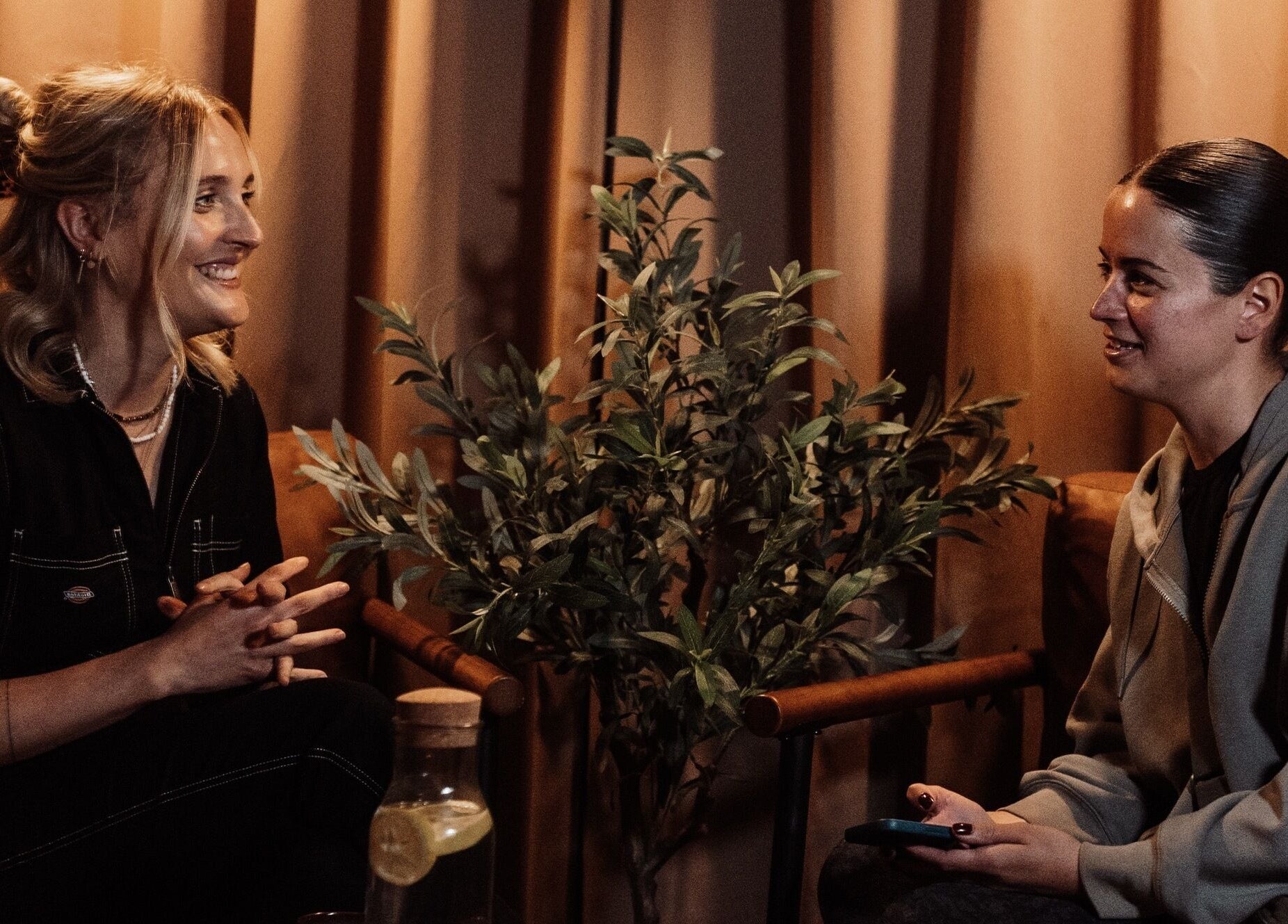 Two people chatting at House of Soul Feniscowles, Feniscowles, England, GB, beside a calming plant.