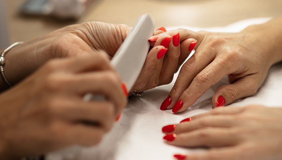 Red manicured nails being filed at HelloWoman Hazelwood, Menlopark, Pretoria, Gauteng, ZA.