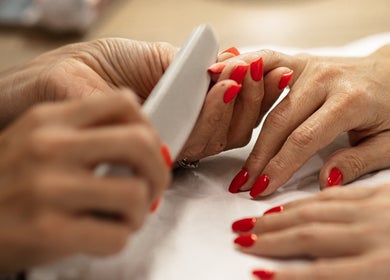 Red manicured nails being filed at HelloWoman Hazelwood, Menlopark, Pretoria, Gauteng, ZA.