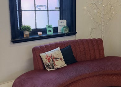 Elegant waiting area at Obsession Hair & Body, Gawler, South Australia, AU with red sofa and decor.