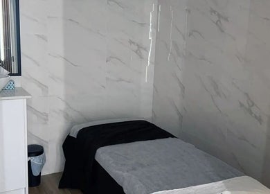 Cozy spa room at Musi Studio in Richmond, British Columbia, CA with a treatment table and sleek basin.