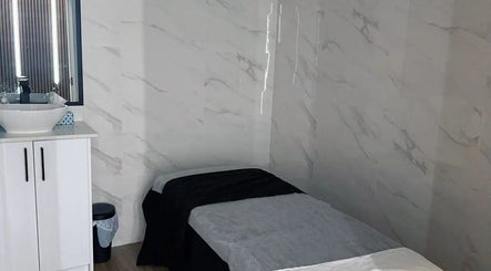 Cozy spa room at Musi Studio in Richmond, British Columbia, CA with a treatment table and sleek basin.