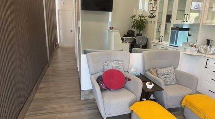 Relaxing area at Musi Studio, Richmond, BC with cozy grey chairs and vibrant yellow accents.