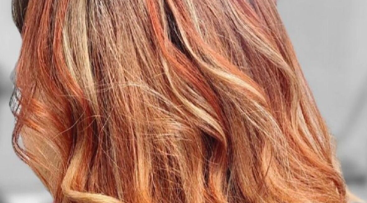 Vibrant red and orange hair design by Hairbyscot in Washington, Missouri, US, showcasing expert coloring techniques.