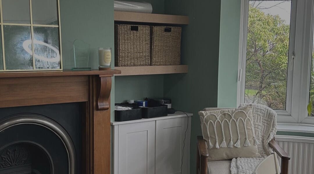 Comfortable lounge area at Glow Girl Club and Megan Tucker PMU in Morriston, Wales, GB with chair and fireplace.