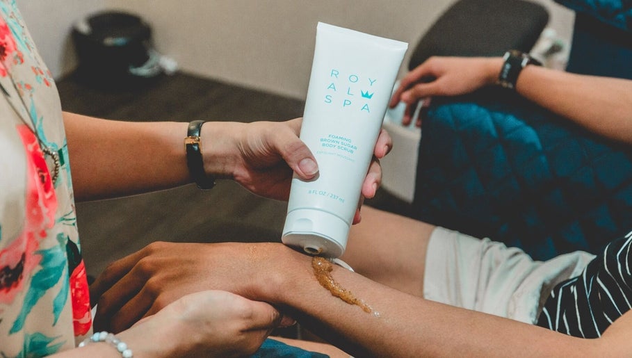 Applying body scrub at Ainrtistry (Home Studio), Singapore for a spa-like skin treatment.