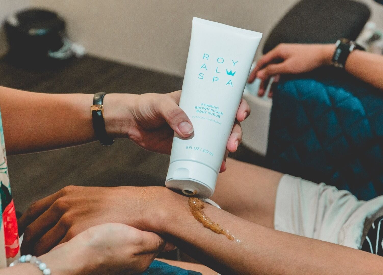 Applying body scrub at Ainrtistry (Home Studio), Singapore for a spa-like skin treatment.