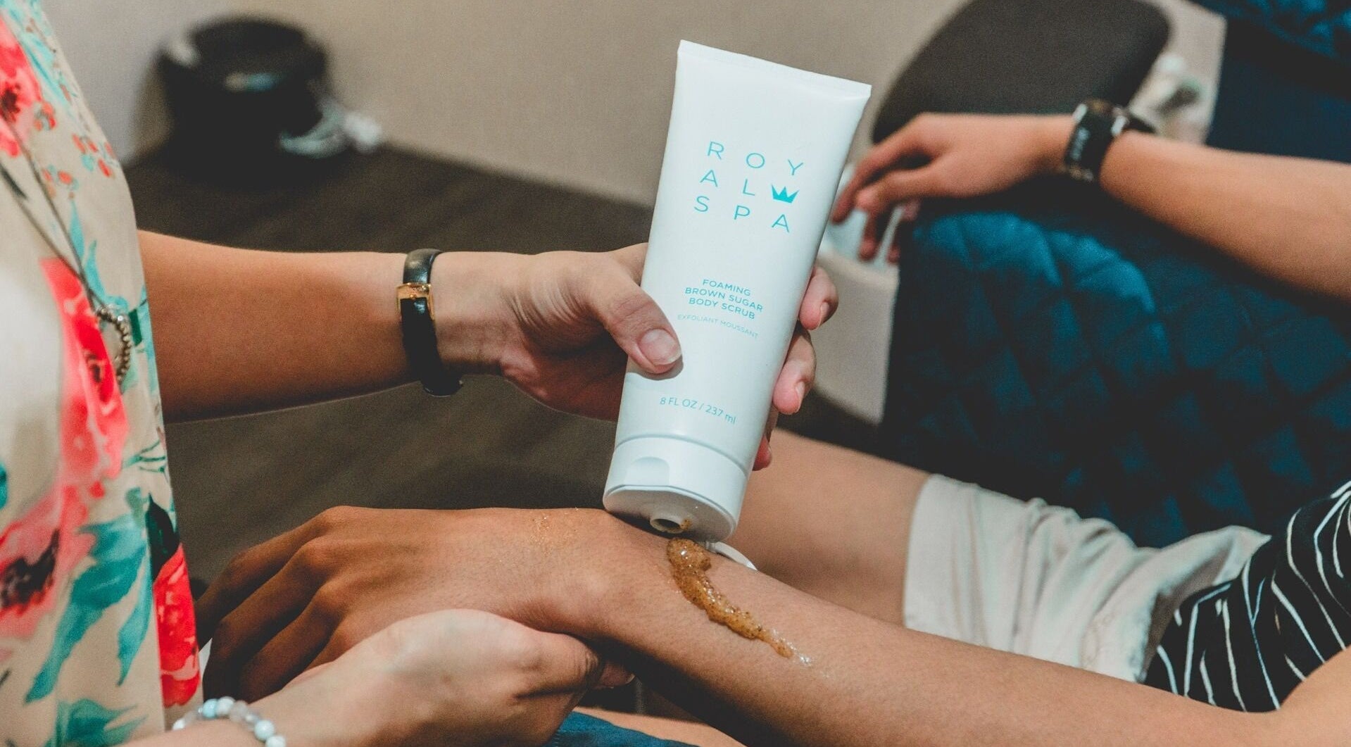 Applying body scrub at Ainrtistry (Home Studio), Singapore for a spa-like skin treatment.