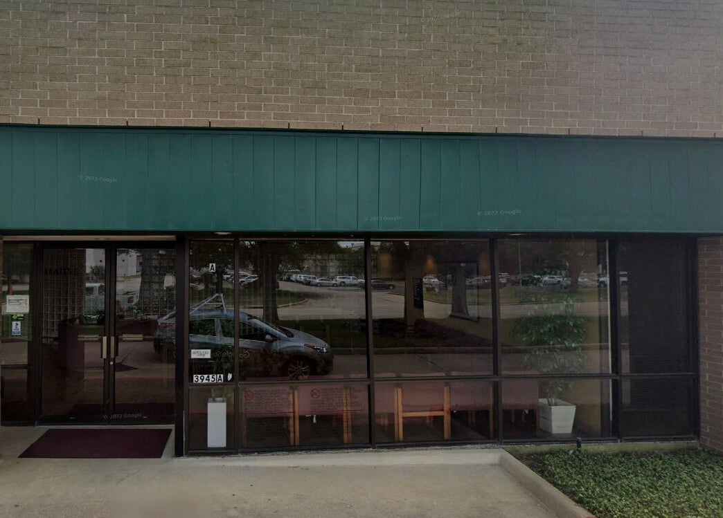Entrance of Lotus Lash Co in Stafford, Texas, US featuring large glass windows and green awning.