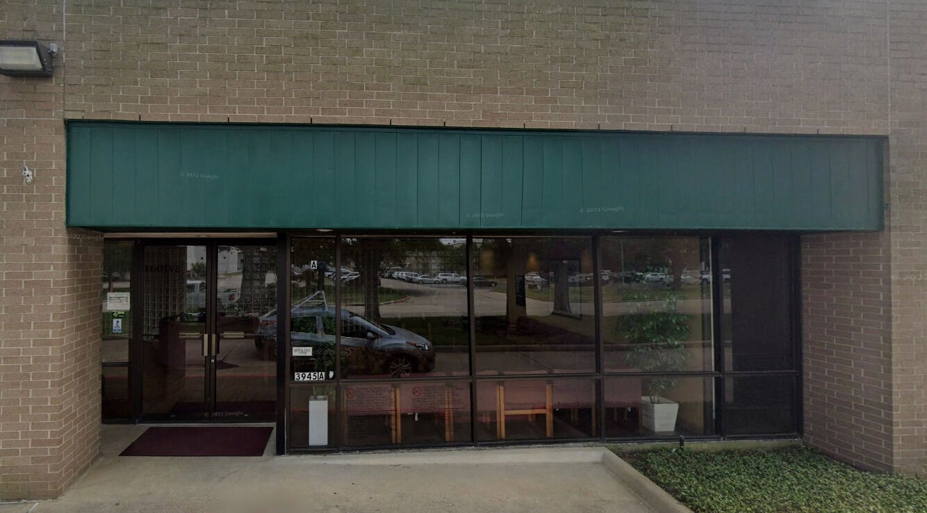 Entrance of Lotus Lash Co in Stafford, Texas, US featuring large glass windows and green awning.