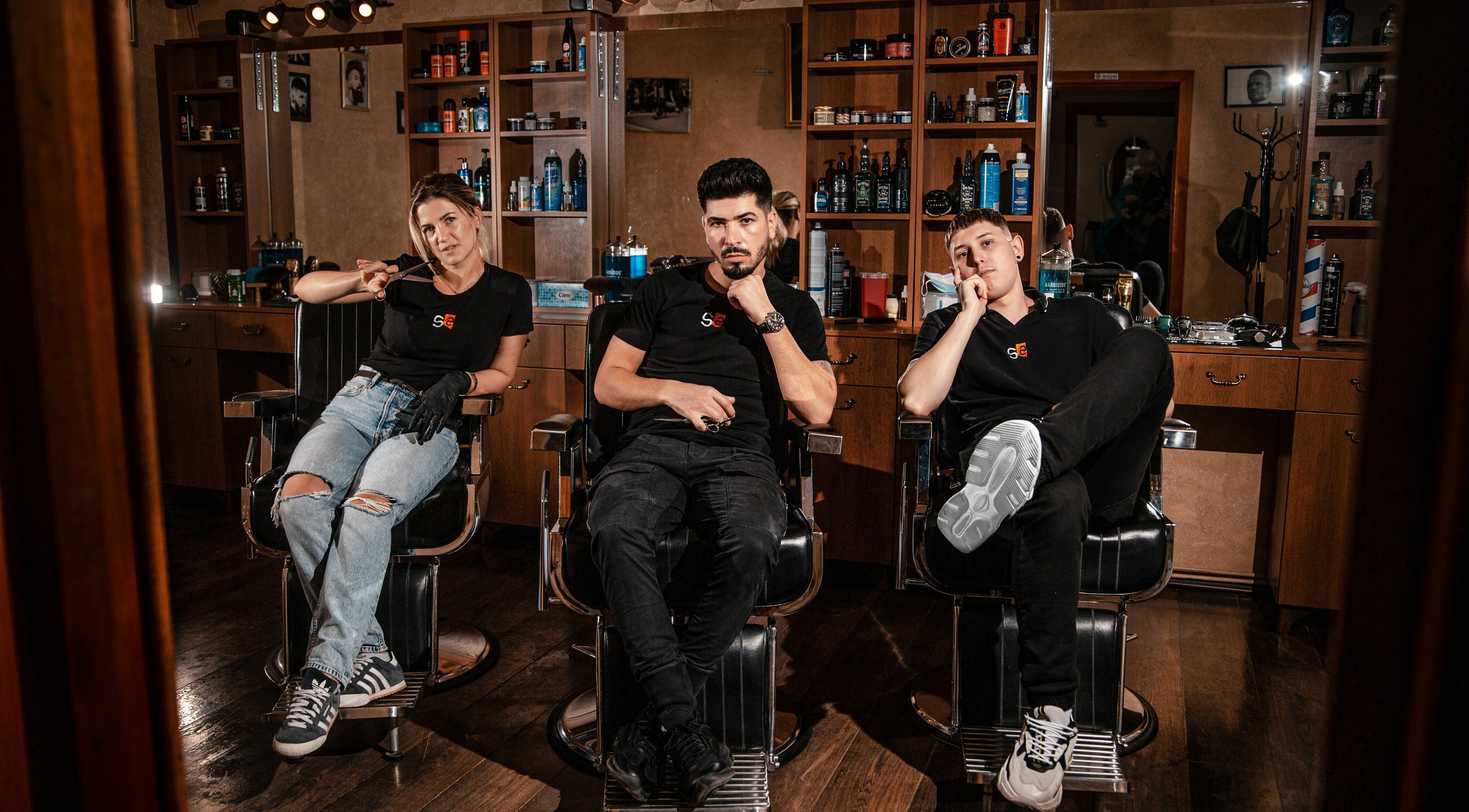 Echipa de stilisti a salonului Stelian din Mizil, Județul Prahova, RO, stând pe scaune de coafor.