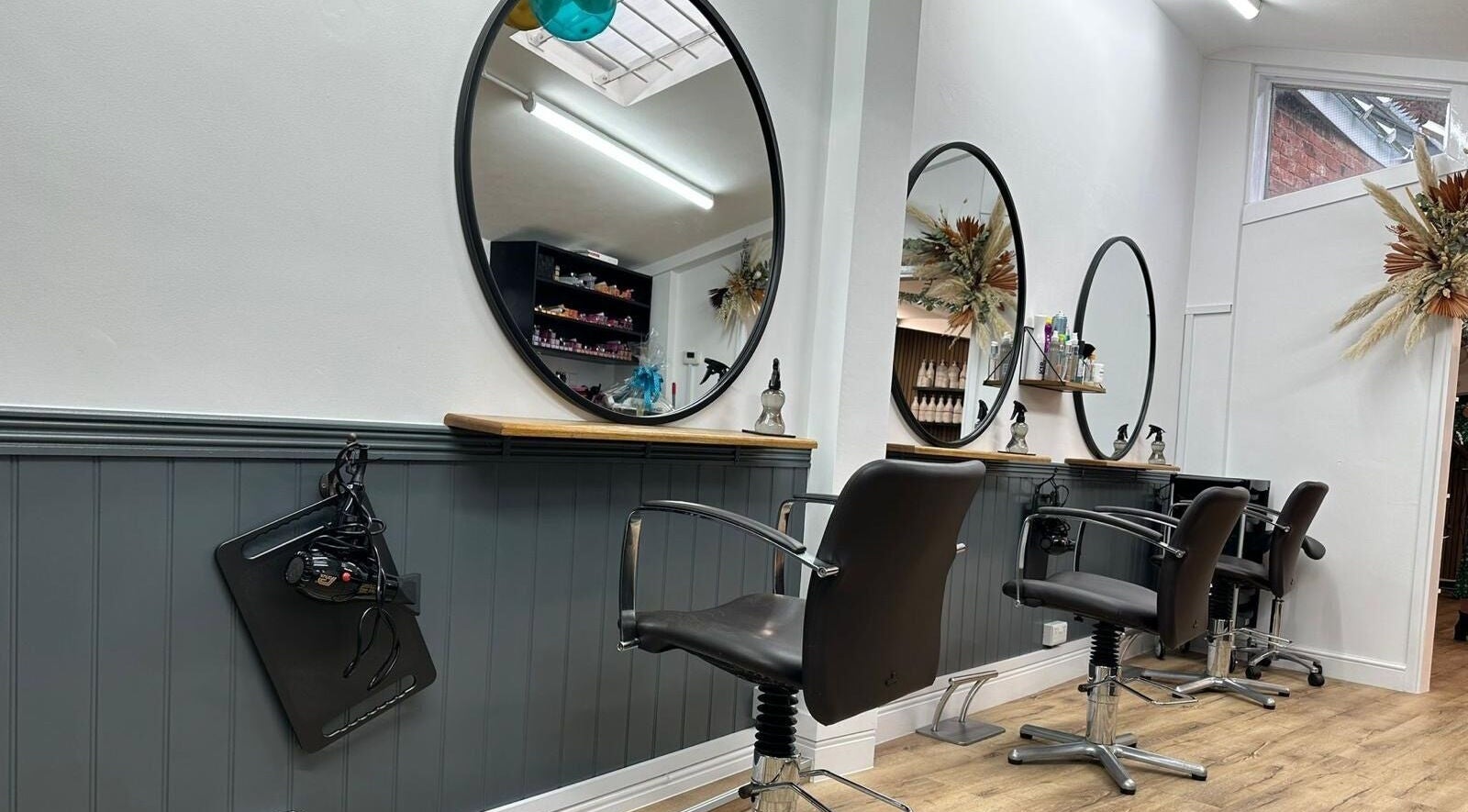 Modern styling stations at Auburn Hair Salon in Leominster, England, GB, featuring sleek decor and mirrors.