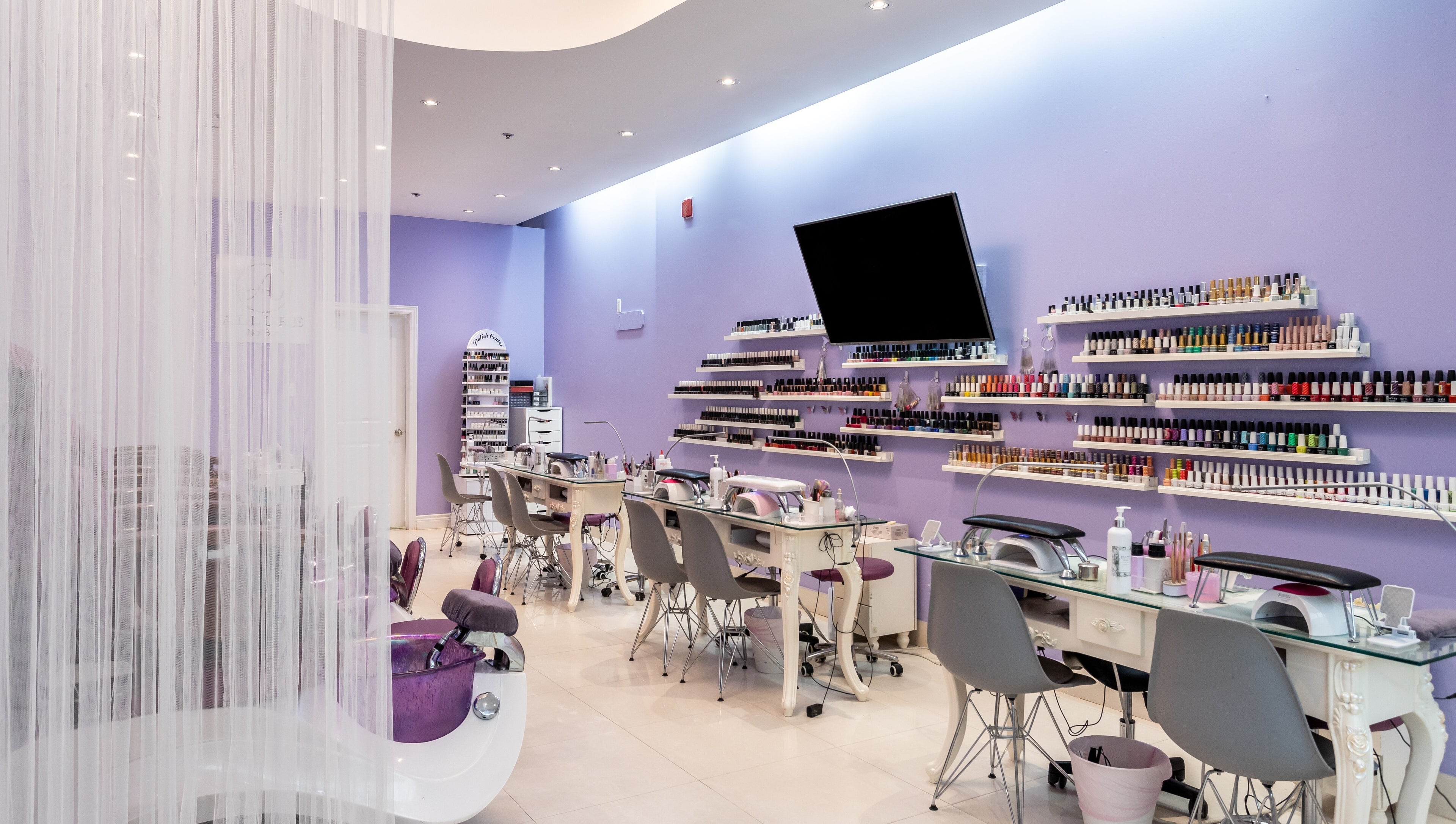 Elegant interior of Allure Nail Bar, Mississauga, Ontario, CA with manicure stations and vibrant nail polish display.