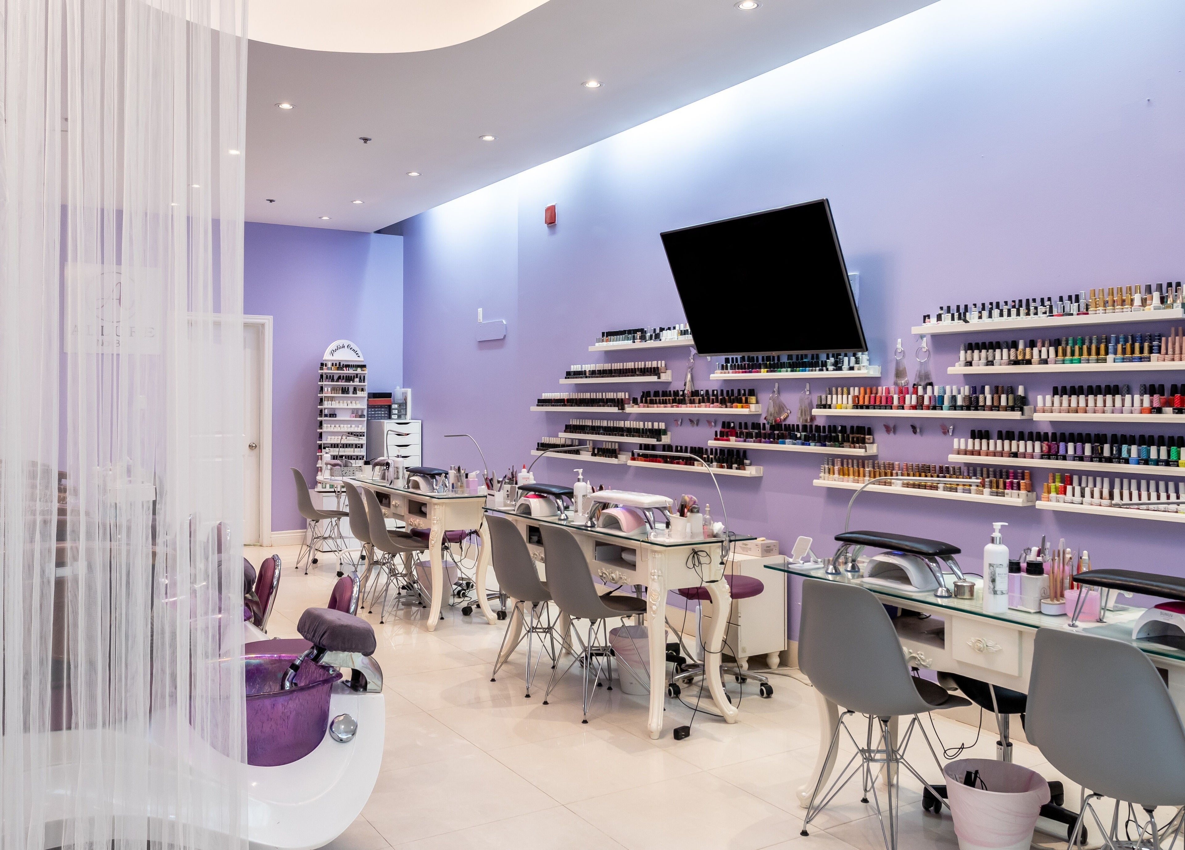 Elegant interior of Allure Nail Bar, Mississauga, Ontario, CA with manicure stations and vibrant nail polish display.