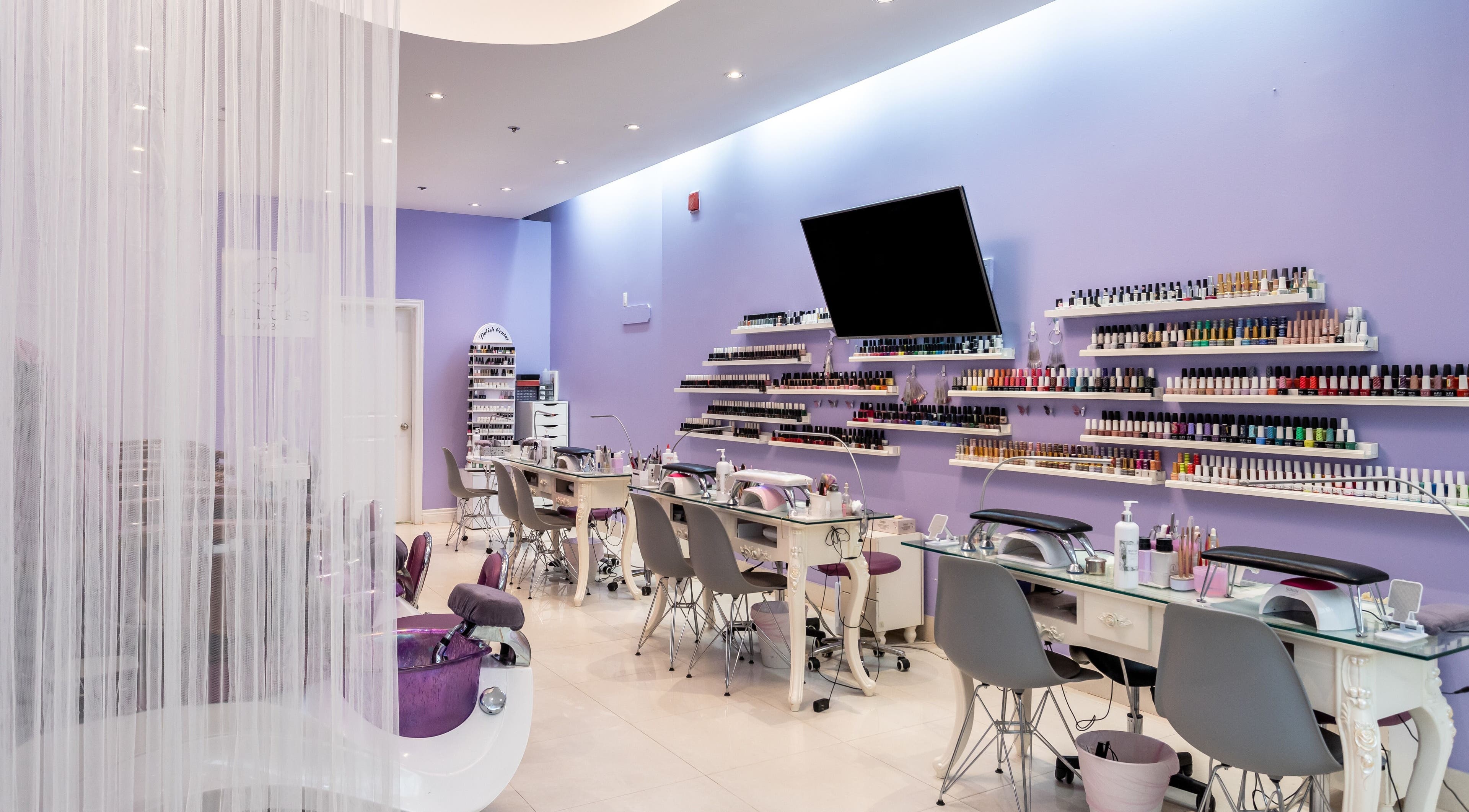 Elegant interior of Allure Nail Bar, Mississauga, Ontario, CA with manicure stations and vibrant nail polish display.