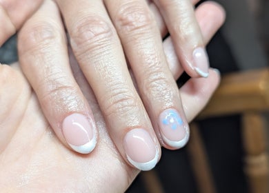 Elegant French manicure with blue floral detail by Gardenia Beauty Mobile Treatments in Blackpool, England, GB.