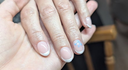 Elegant French manicure with blue floral detail by Gardenia Beauty Mobile Treatments in Blackpool, England, GB.