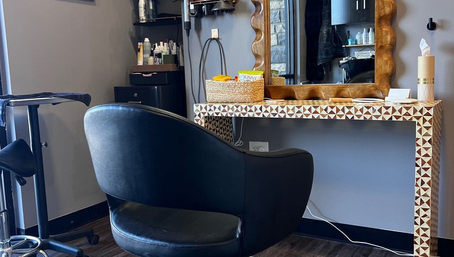 Stylish salon station at Mariah Allison Hair, Flower Mound, Texas, US with elegant black chair and products.