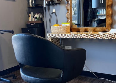 Stylish salon station at Mariah Allison Hair, Flower Mound, Texas, US with elegant black chair and products.