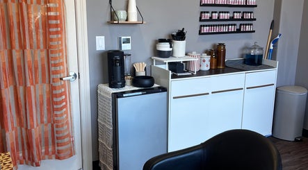 Refreshment station in Mariah Allison Hair, Flower Mound, Texas, US, featuring a coffee maker and shelves.