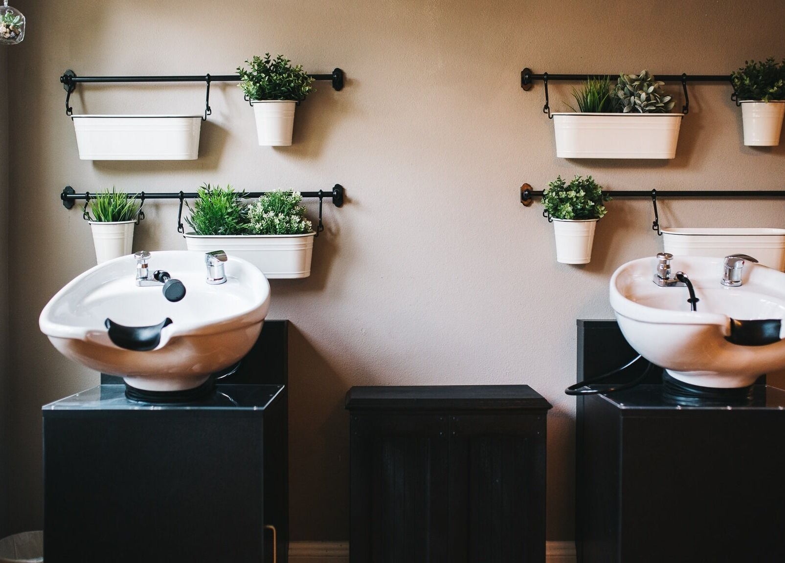 Luxury salon wash stations at The Emerald Fox, Tavares, Florida, US with vibrant plants on walls.