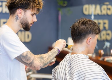 Skilled barber at Grand Royal Barbers - Darlinghurst performing a haircut in Sydney, New South Wales, AU.