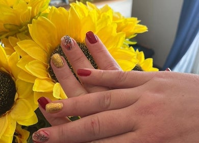 Stylish nail art at Star Glam Nails, Sandton, Gauteng, ZA, featuring sunflower-inspired designs and bright colors.