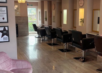 Inside Trim N Tonic salon in Teignmouth, England, GB, featuring award displays and stylish salon chairs.