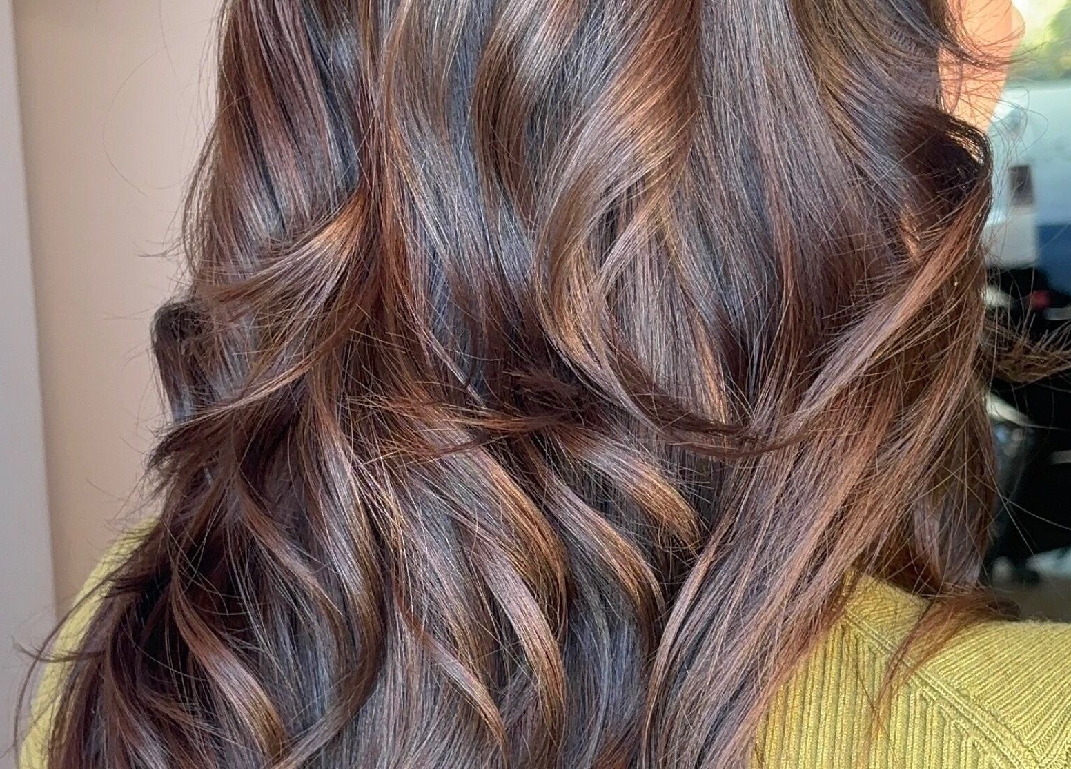 Close-up of wavy, glossy brunette hair styled at Trim N Tonic, Teignmouth, England, GB.
